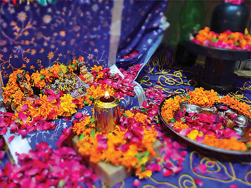 a lamp is lit among other offerings at a local temple for diwali photo express