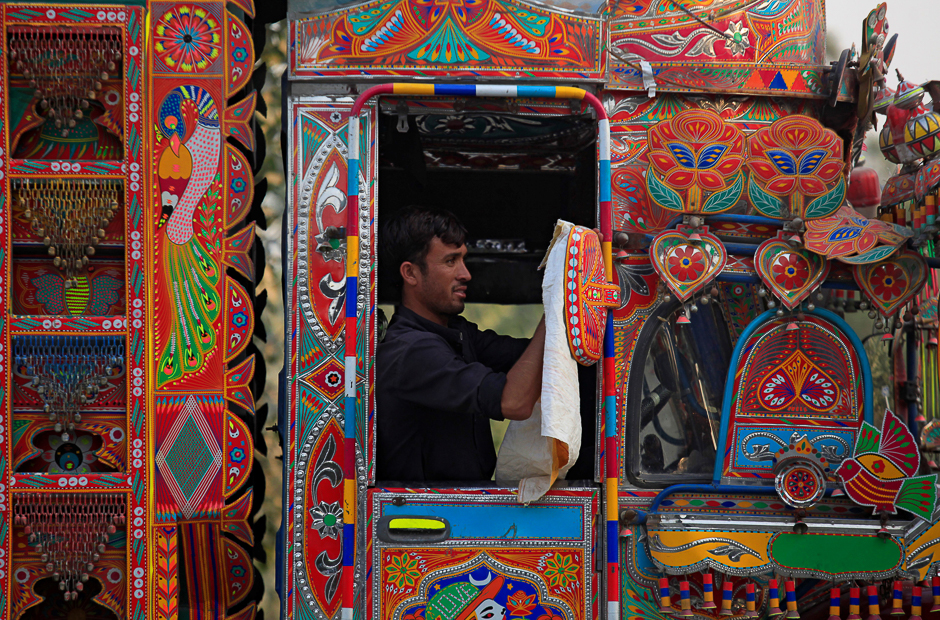 A truck driver cleans the mirror of his decorated truck in Charsadda outside Peshawar, Pakistan. PHOTO: REUTERS