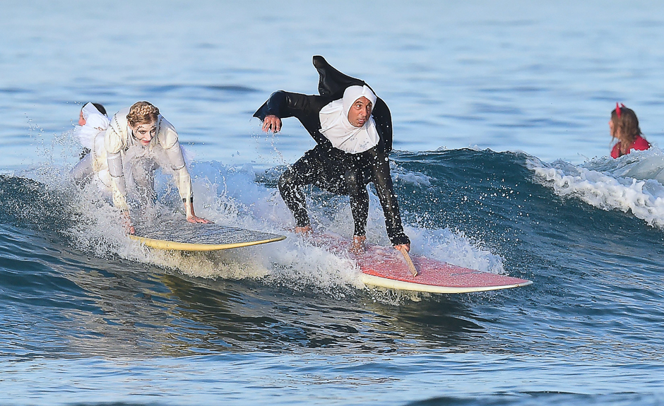 Husband and wife Erik and April Torregroza catch a wave at Blackie's 10th annual Halloween Surf contest in Newport Beach, California. PHOTO: AFP