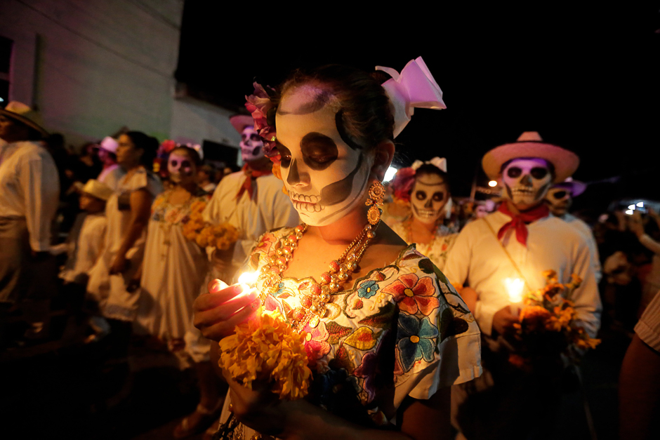 Residents with painted faces and holding candles participate in El Paseo de Las Almas,The Walk of Souls, during a Day of the Dead festival in Merida, Yucatan, Mexico. PHOTO: AFP