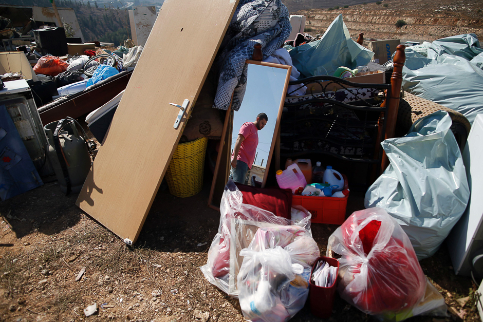 A Palestinian man searches through his belongings after his family home was demolished by workers from the Jerusalem municipality in the mostly Arab east Jerusalem neighbourhood of Beit Hanina. Palestinian homes built without an Israeli construction permit are often demolished by order of the Jerusalem municipality. PHOTO: AFP