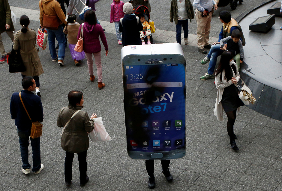 A participant wearing costume symbolising Samsung Galaxy Note 7 walks among pedestrians after a Halloween parade in Kawasaki, south of Tokyo, Japan. PHOTO: REUTERS