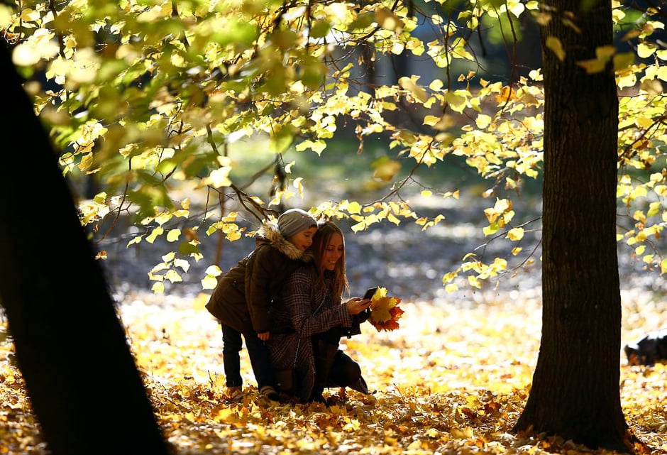 A woman and a child enjoy an autumn sunny day in central park in Minsk, Belarus, Oct.13. PHOTO: REUTERS