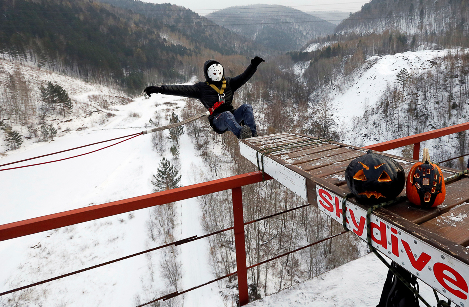 A member of the Exit Point amateur rope-jumping group wearing a Halloween mask jumps from a 44-metre-high (144-ft) water pipe bridge to mark the end of the group's jumping season and recent Halloween festivities, in the Siberian Taiga area outside Krasnoyarsk, Russia. PHOTO: REUTERS