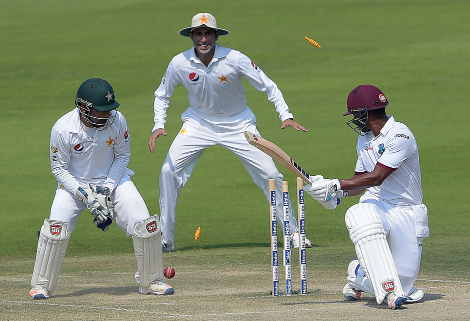 West Indies' batsman Leon Johnson (R) is bowled out by Pakistani spinner Yasir Shah (unseen) as wicketkeeper Sarfraz Ahmed (L) and teammate Younis Khan look on during the fourth day of the second Test between Pakistan and the West Indies at the Sheikh Zayed Cricket Stadium in Abu Dhabi. PHOTO: AFP