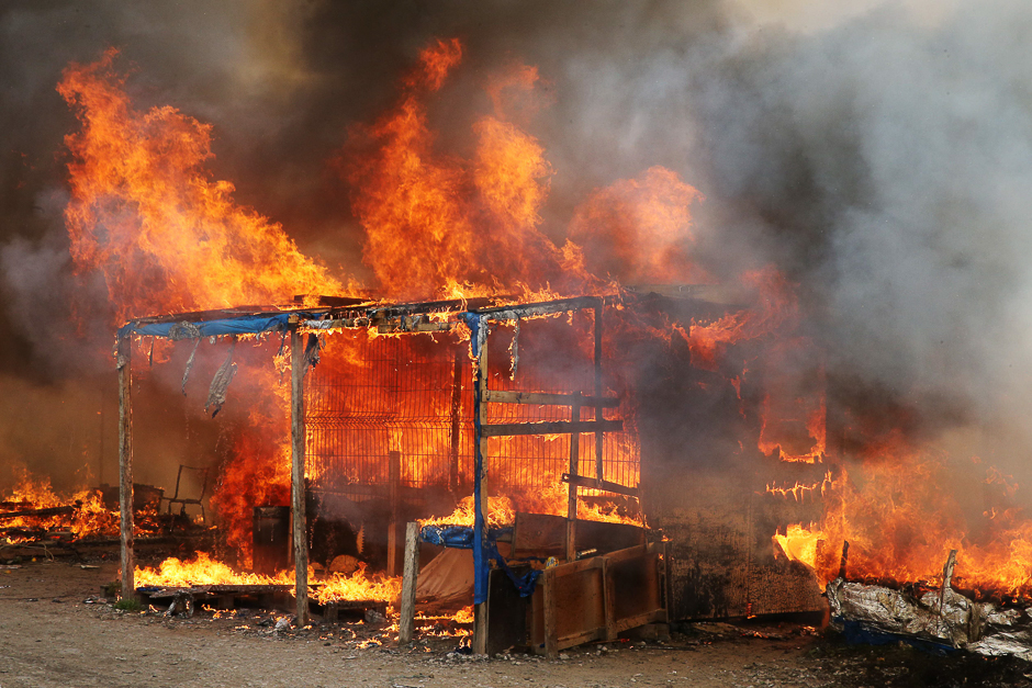 A fire burns a makeshift shelter at the 