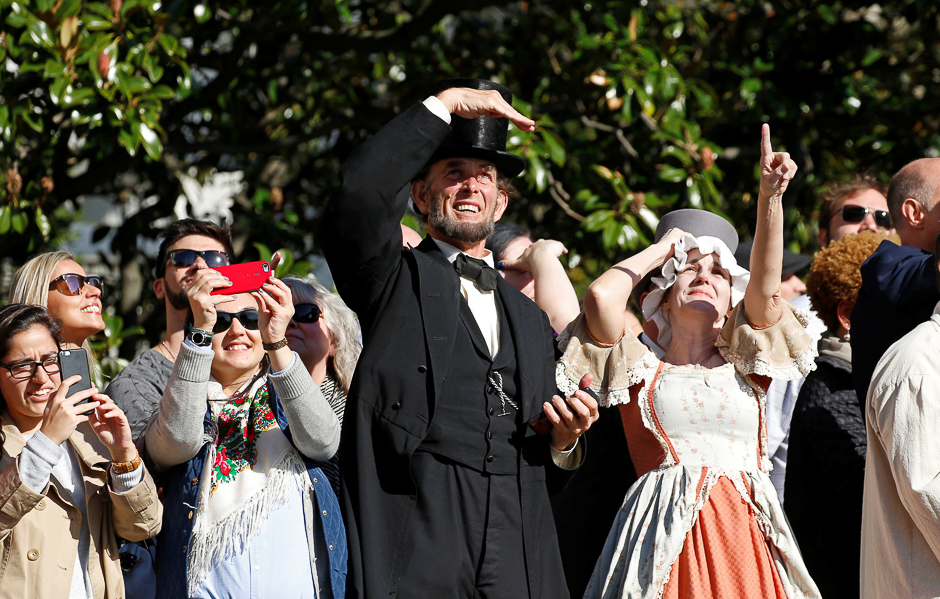 Actors dressed as President Abraham Lincoln (C) and first lady Abigail Adams (R) look up as they watch US. President Barack Obama depart the White House aboard Marine One in Washington. PHOTO: REUTERS