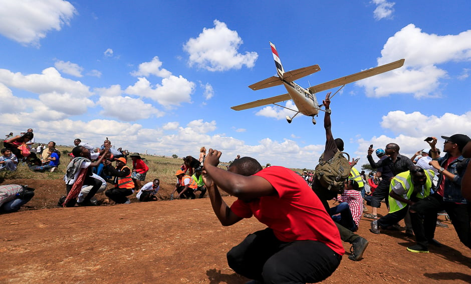 Spectators react as a plane flies over them during the Vintage Air Rally at the Nairobi national park in Kenya's capital Nairobi. PHOTO: REUTERS