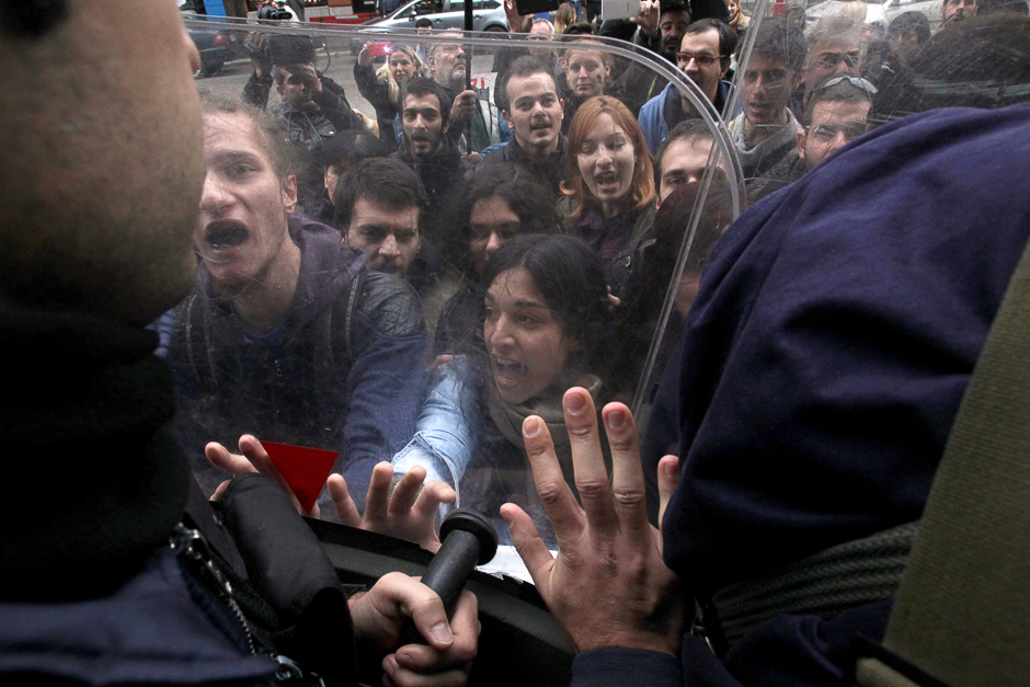 Demonstrators scuffle with riot police officers during a protest against home auctions outside a Bank of Greece branch in Thessaloniki, Greece. PHOTO: REUTERS