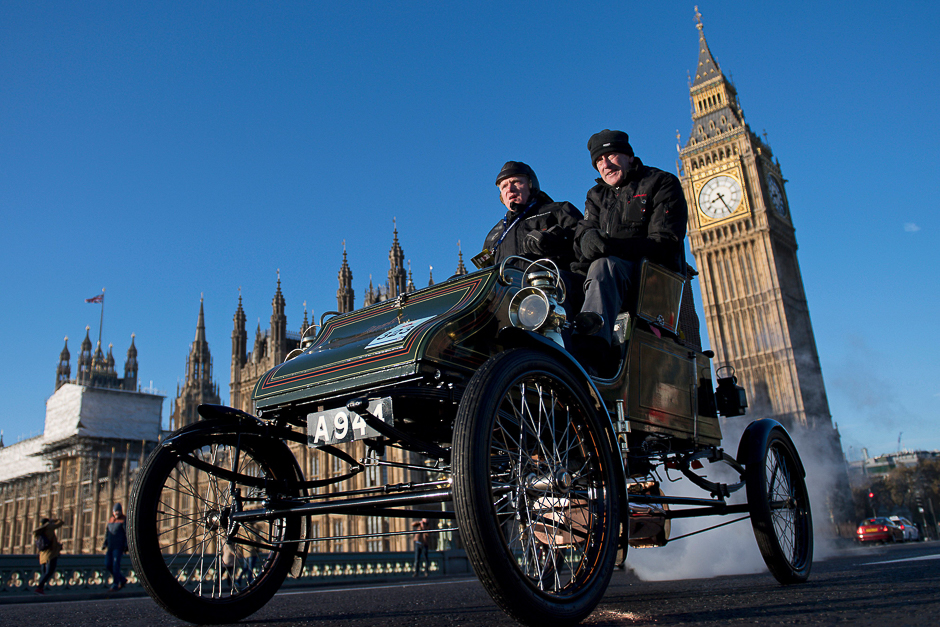 A vintage car is driven past the Houses of Parliament in Westminster shortly after beginning the 120th 