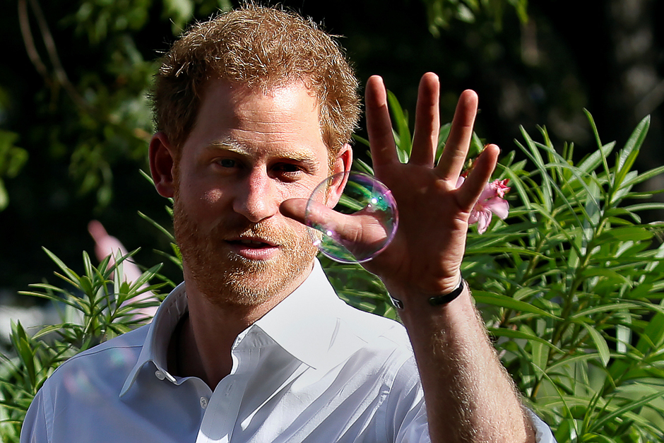 Prince Harry tries to catch a bubble as he attends a charity event during his official visit in St. John's, Antigua. PHOTO: REUTERS