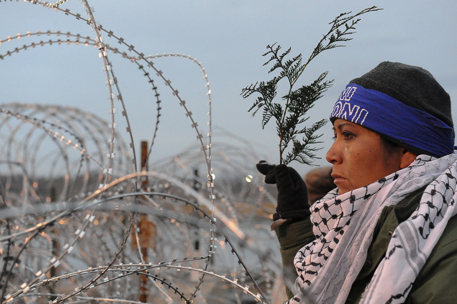 A woman holds a branch of cedar during a prayer ceremony on Backwater Bridge during a protest against plans to pass the Dakota Access pipeline near the Standing Rock Indian Reservation, near Cannon Ball, North Dakota, US. PHOTO: REUTERS