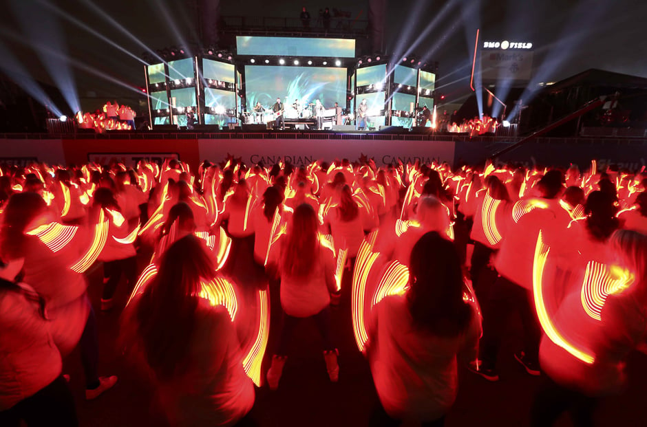 Performers are streaked with light as recording artists OneRepublic perform during the halftime show at the Canadian Football League's (CFL) 104th Grey Cup championship game in Toronto, Ontario, Canada. PHOTO: REUTERS