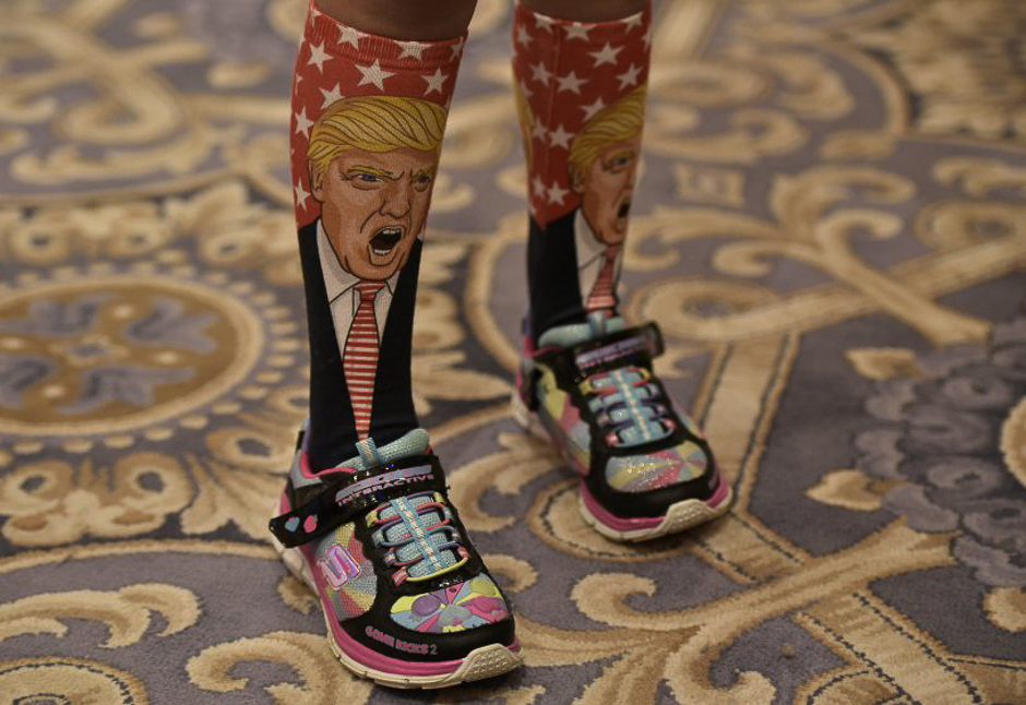 TOPSHOT - A young supporter wears socks with the image of Republican presidential nominee Donald Trump ahead of his press conference at the Trump International Hotel, in Washington, DC on September 16, 2016. / AFP / MANDEL NGAN (Photo credit should read MANDEL NGAN/AFP/Getty Images)