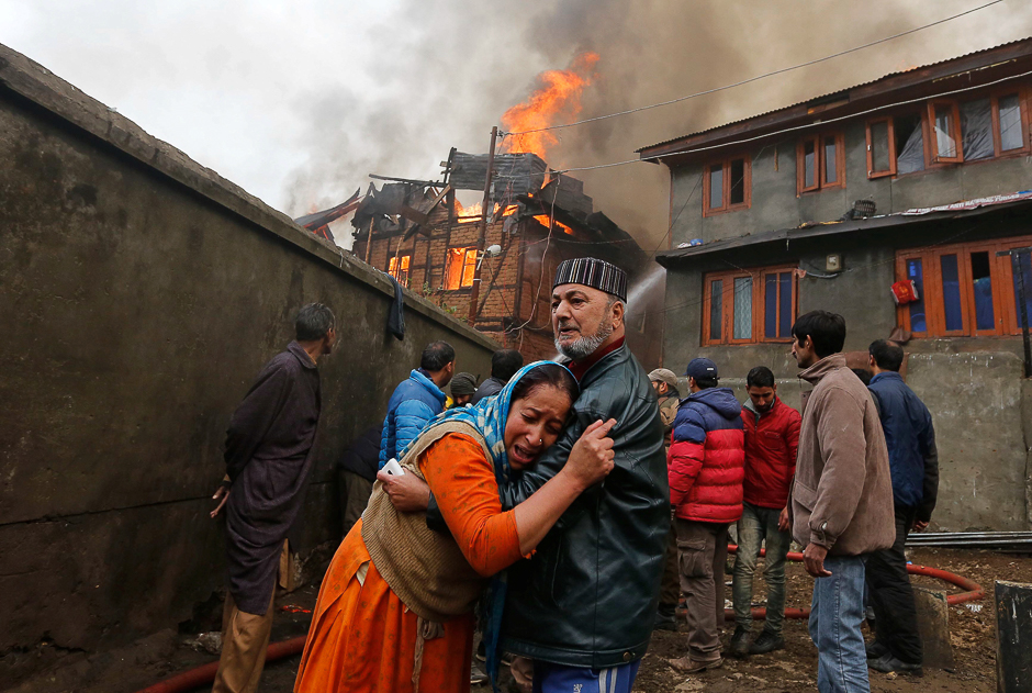 Woman is consoled by her relative as she mourns after seeing her house getting burned during a fire that broke out in one of the houses and got spread in more adjoining houses, in a residential locality in Srinagar. PHOTO: REUTERS