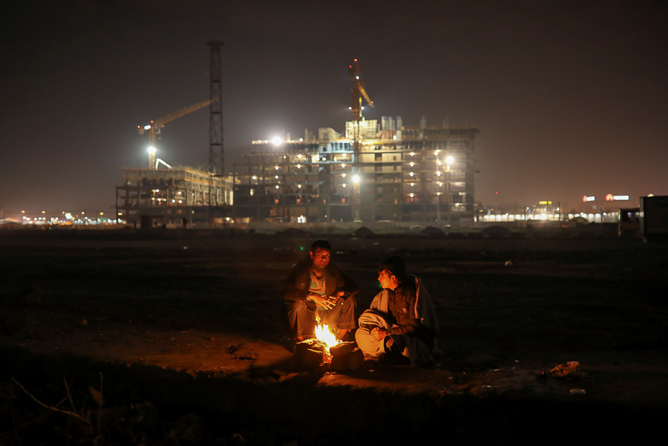 Migrants warm themselves by the fire outside a derelict customs warehouse in Belgrade, Serbia. PHOTO: REUTERS