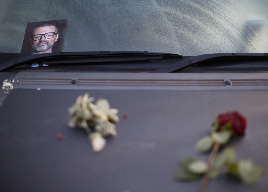 A photograph and rose lie on a car in tribute to singer George Michael outside of his home in north London, Britain. PHOTO: REUTERS
