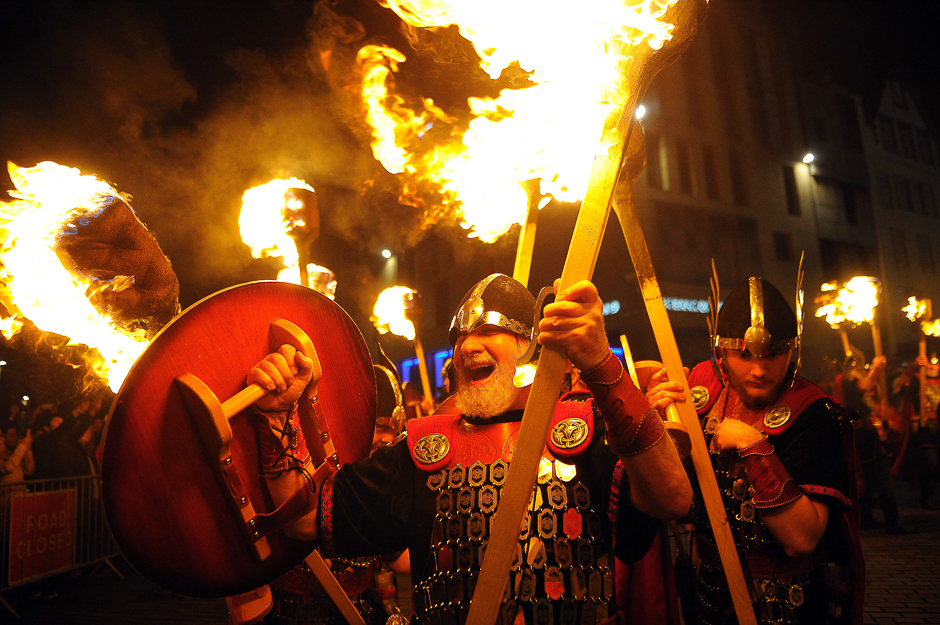 Members of the Up Helly AA Vikings from Shetland light their torches as they prepare to take part in a torchlit procession through the streets of Edinburgh in Scotland, as the city begins to celebrate Hogmanay. PHOTO: AFP