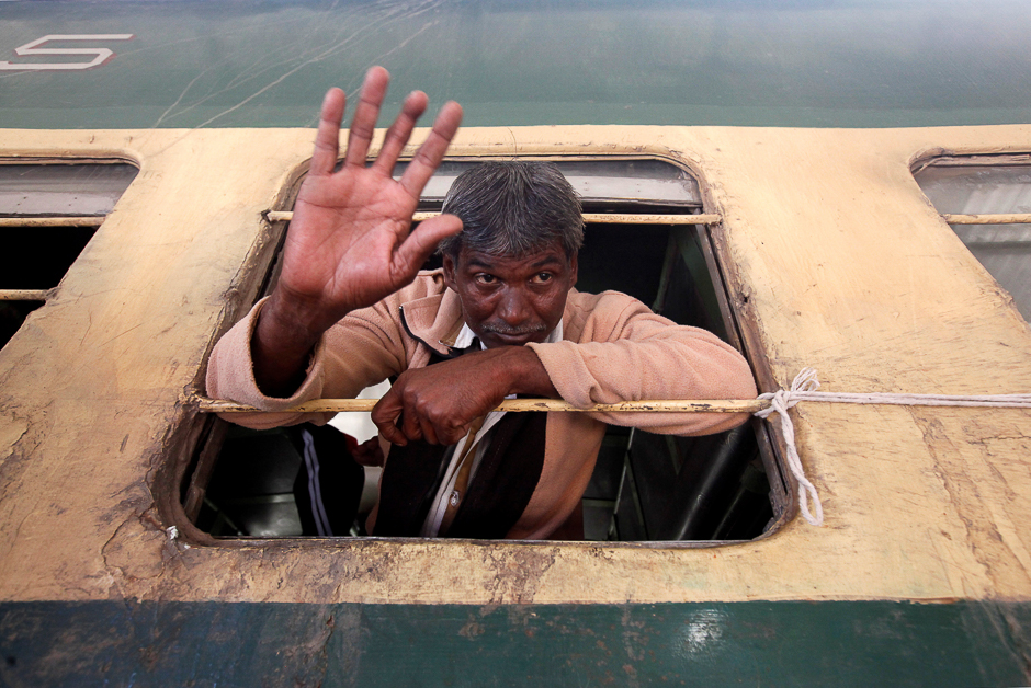 A fisherman from India waves from a window of a train, after he was released with others from a prison, at Cantonment railway station in Karachi. PHOTO: REUTERS