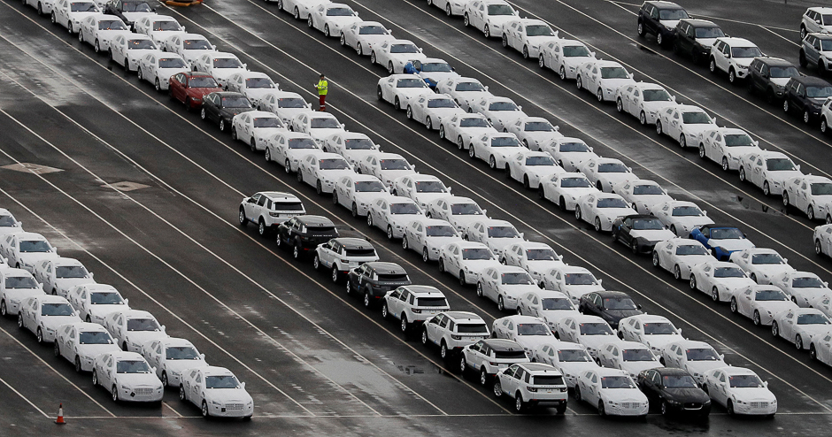 A worker walks between rows of Jaguar and Land Rover cars as they wait to be shipped from Peel Ports container terminal in Liverpool, northern England, Britain. PHOTO: REUTERS