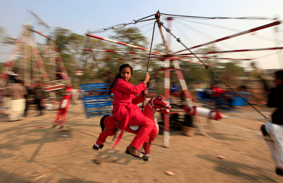 A girl rides on a makeshift merry go round on Christmas Day in Islamabad, Pakistan. PHOTO: REUTERS