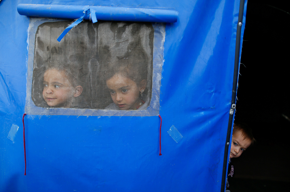 Displaced Iraqi children, who fled the Islamic State stronghold of Mosul, look through a window in a tent in Khazer refugee camp, east of Mosul, Iraq. PHOTO: REUTERS