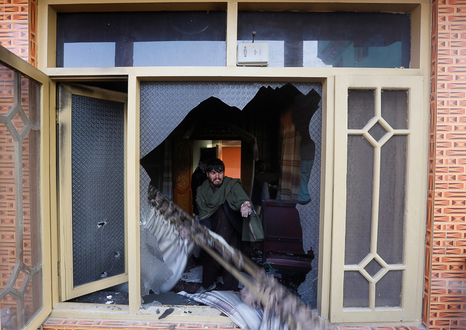 An Afghan man removes the burning items from the house of an Afghan member of parliament, which was attacked by Taliban last night in Kabul, Afghanistan. PHOTO: REUTERS