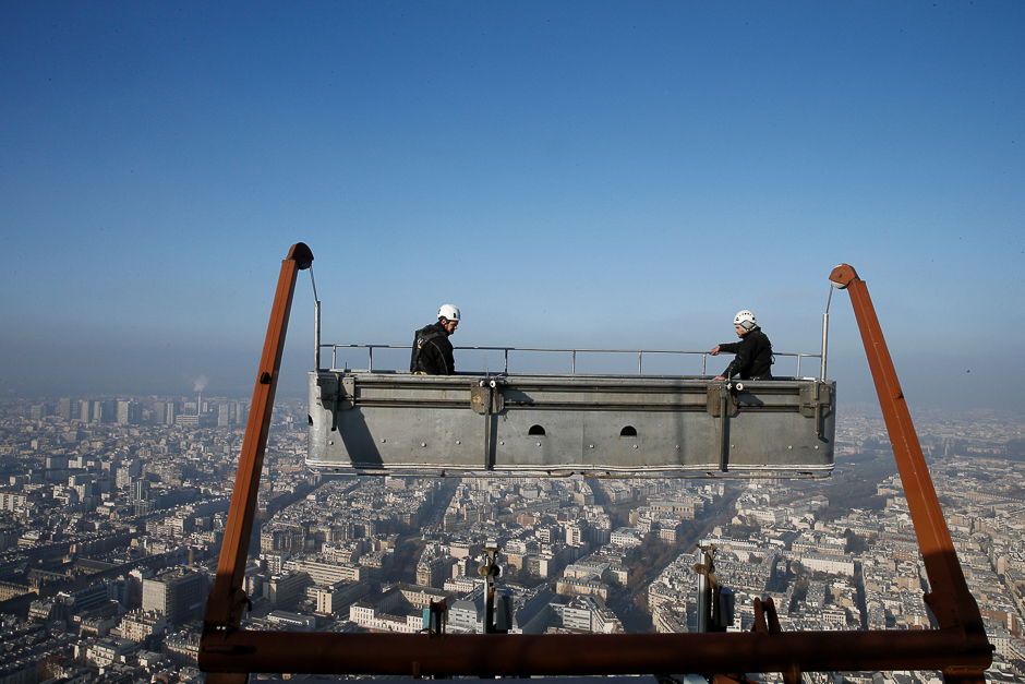A small-particle haze hangs above the skyline as workers clean the windows of the Montparnasse tower in Paris, France. PHOTO: REUTERS
