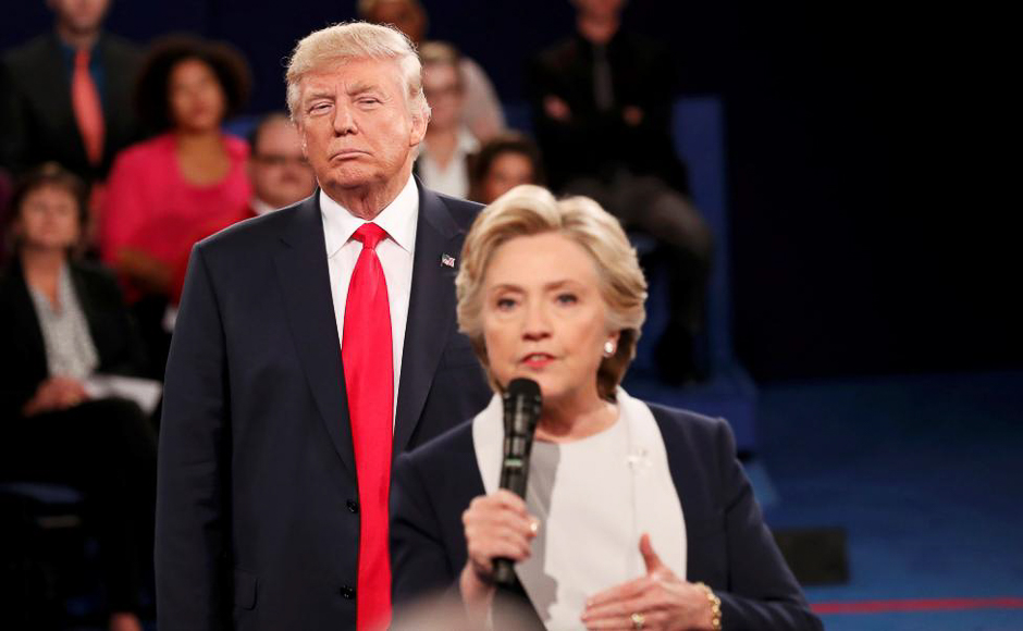 Donald Trump listens as Hillary Clinton answers a question from the audience during their presidential town hall debate at Washington University in St. Louis, Missouri, October 9, 2016. PHOTO: REUTERS