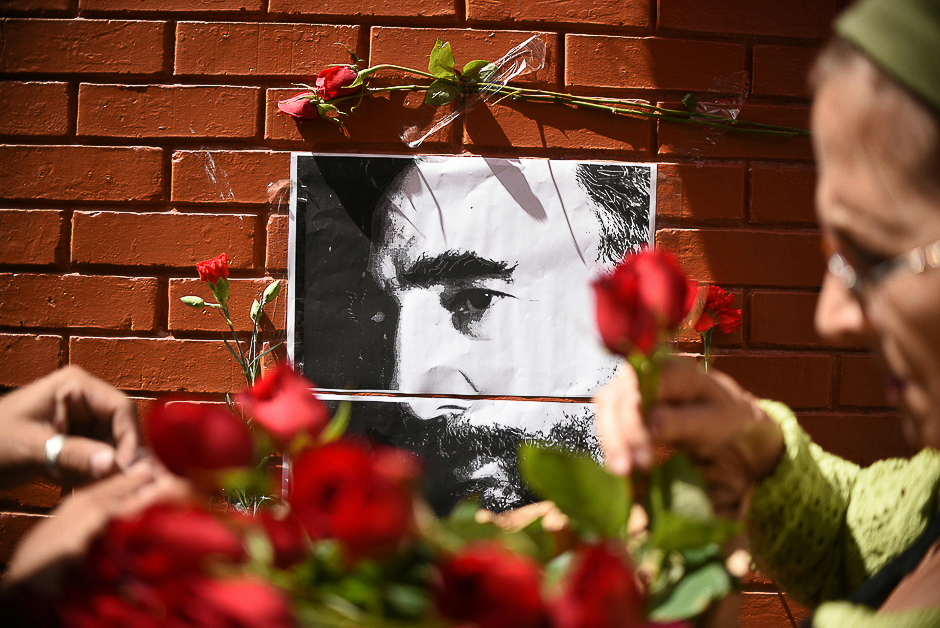 People place flowers next to a portrait of Cuban historic revolutionary leader Fidel Castro outside the Cuban embassy in Guatemala City. PHOTO: AFP