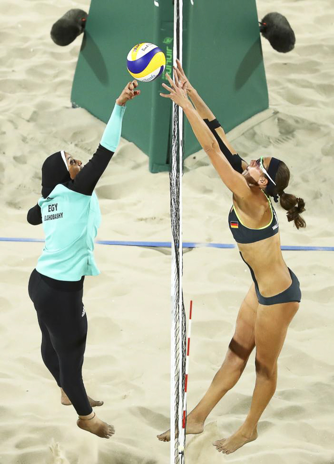 Doaa Elghobashy of Egypt and Kira Walkenhorst of Germany compete in the preliminary beach volleyball event at the Rio Olympics August 7, 2016. PHOTO: REUTERS