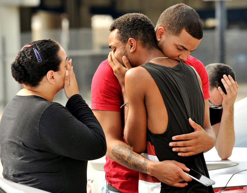 Friends and family members embrace outside the Orlando Police Headquarters during the investigation of a shooting at the Pulse night club, where as many as 20 people have been injured after a gunman opened fire, in Orlando, Florida, June 12, 2016. PHOTO: REUTERS