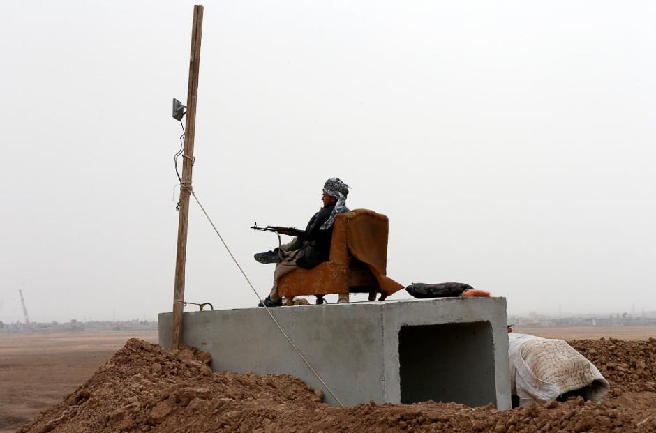 A Kurdish Peshmerga fighter looks over Mosul from his position near Abu Jarboa village, Iraq. PHOTO: REUTERS 