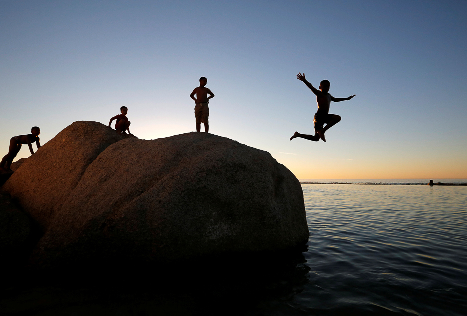 Children leap into a tidal pool as temperatures soar at Camps Bay beach in Cape Town, South Africa. PHOTO: REUTERS