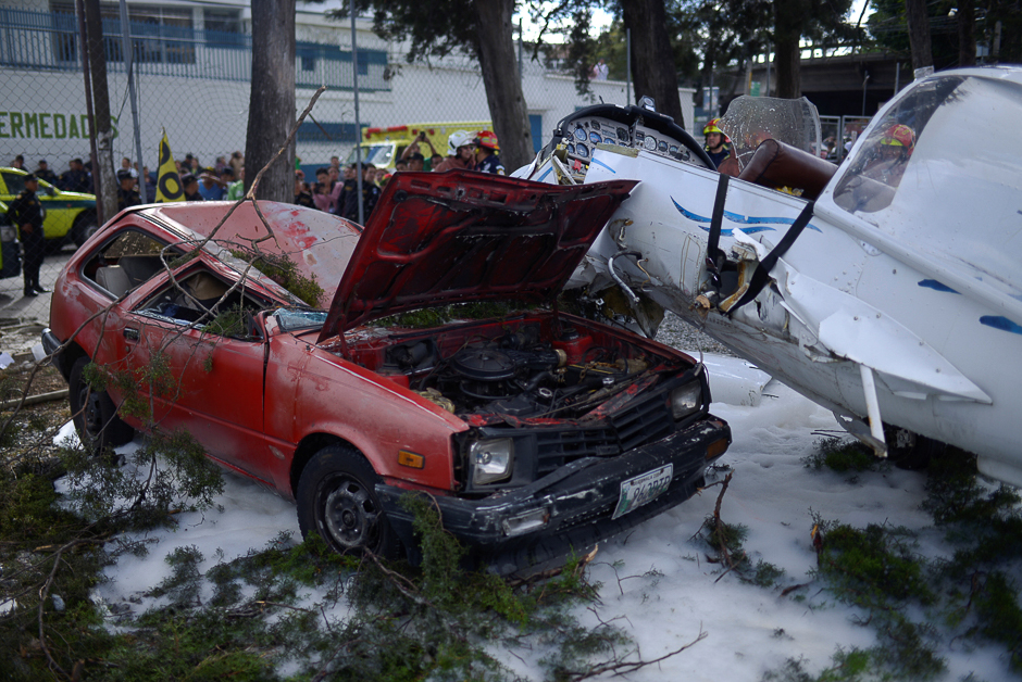 A plane, which crashed into an empty car is pictured on the ground after fire-fighters sprayed with foam in a parking lot, in Guatemala City, Guatemala. PHOTO: REUTERS