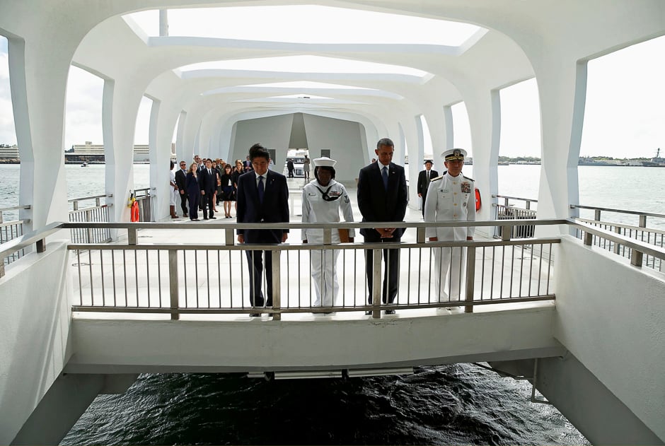 Japanese Prime Minister Shinzo Abe (L) and US President Barack Obama pause after participating in a wreath-laying ceremony aboard the USS Arizona Memorial at Pearl Harbor, Hawaii, US. PHOTO: REUTERS