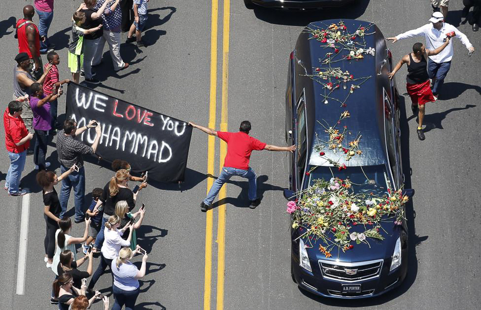 A well-wisher holding a banner touches the hearse carrying the remains of Muhammad Ali during the funeral procession for the three-time heavyweight boxing champion in Louisville, Kentucky. PHOTO: REUTERS