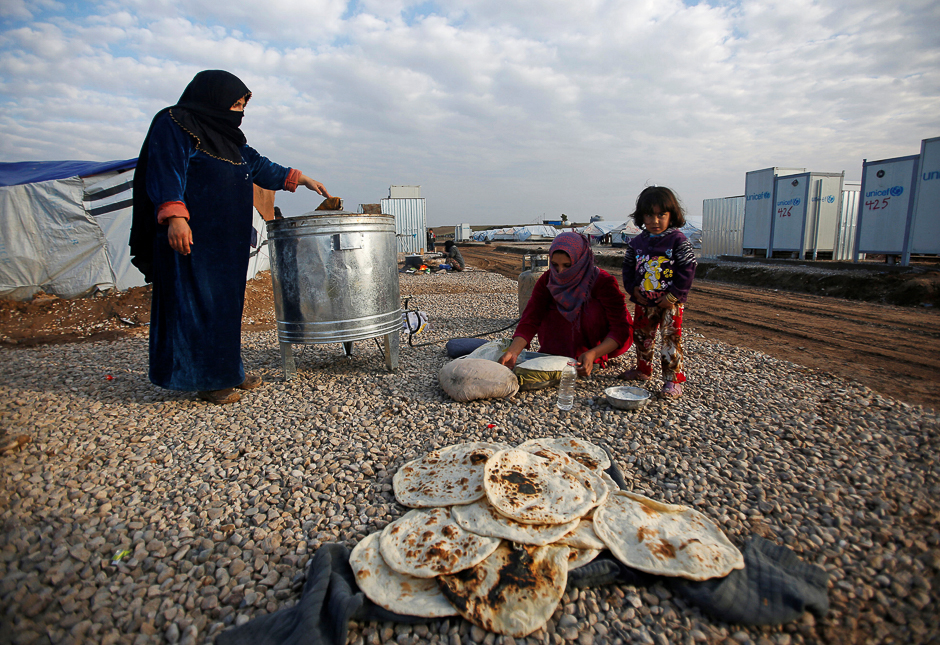 Displaced women, who fled the Islamic State stronghold of Mosul, make bread at Hassan Sham camp, east of Mosul, Iraq. PHOTO: REUTERS