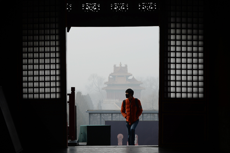 A man wearing a mask visits the Forbidden City in Beijing. Beijing issued its first air pollution red alert for 2016 on December 15, with choking smog expected to cover the city and surrounding areas in north China until December 21. PHOTO: AFP