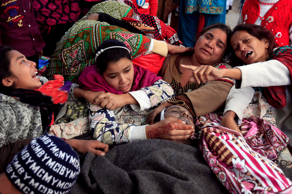 Family members mourn over the body of a relative, who died after consuming locally made toxic liquor, in Toba Tek Singh, Pakistan. PHOTO: REUTERS