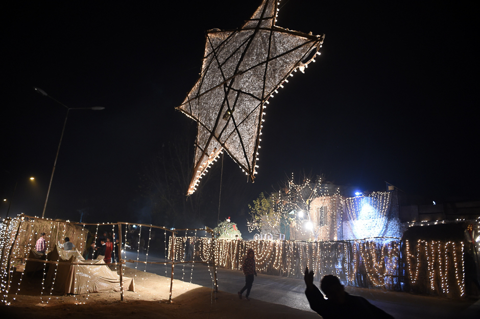 Pakistani Christian children walk past the lights decoration for Christmas celebration in Islamabad. PHOTO: AFP