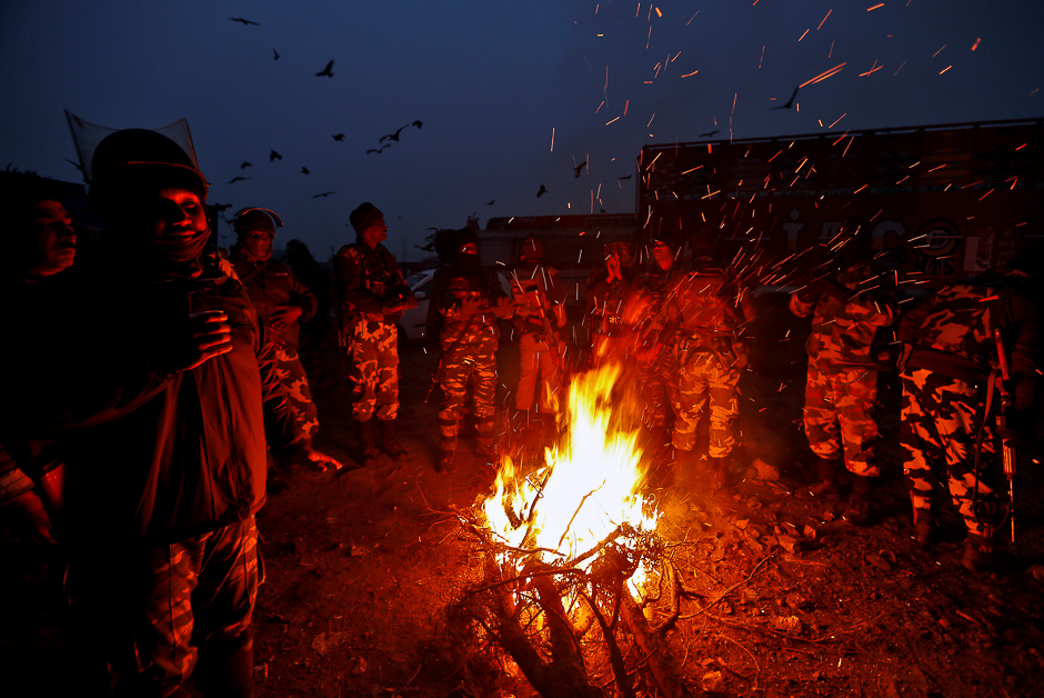 Indian soldiers warm themselves by a bonfire on a cold winter morning in Srinagar, November 29, 2016. REUTERS/Danish Ismail