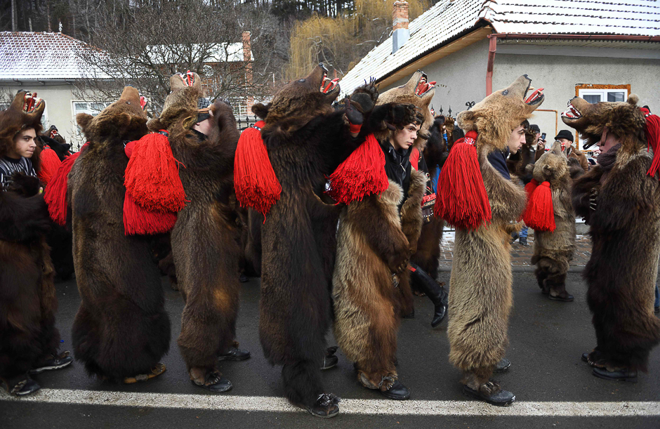 People wearing bear skins dance in the streets of Comanesti, Romania during a parade to drive away evil spirits of the past year. PHOTO: AFP