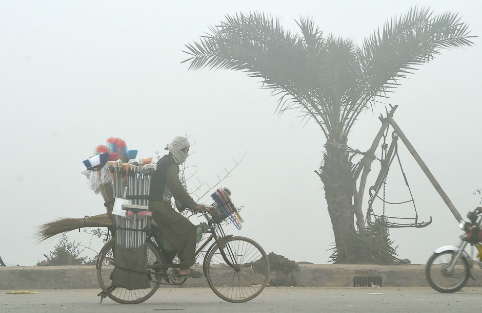 A Pakistani vendor rides his bicycle along a street during fog in Lahore. PHOTO: AFP