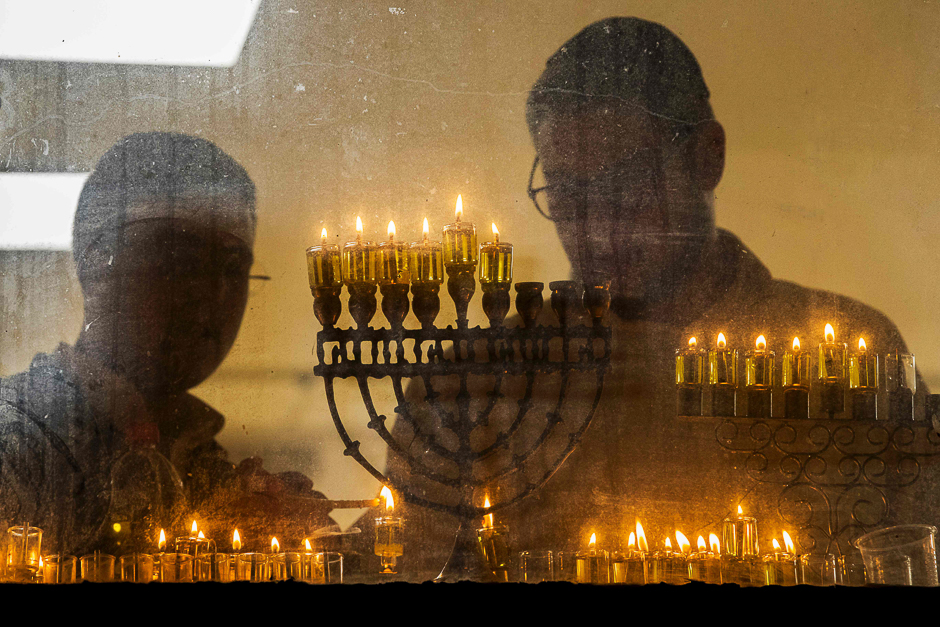 Students from a Yeshiva religious school light candles on a menorah during the Jewish holiday of Hannukah, the festival of lights, in the central Israeli city of Bnei Brak near Tel Aviv. PHOTO: AFP