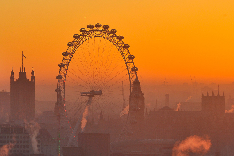 The sun sets behind the Houses of Parliament and the London Eye in central London. PHOTO: AFP