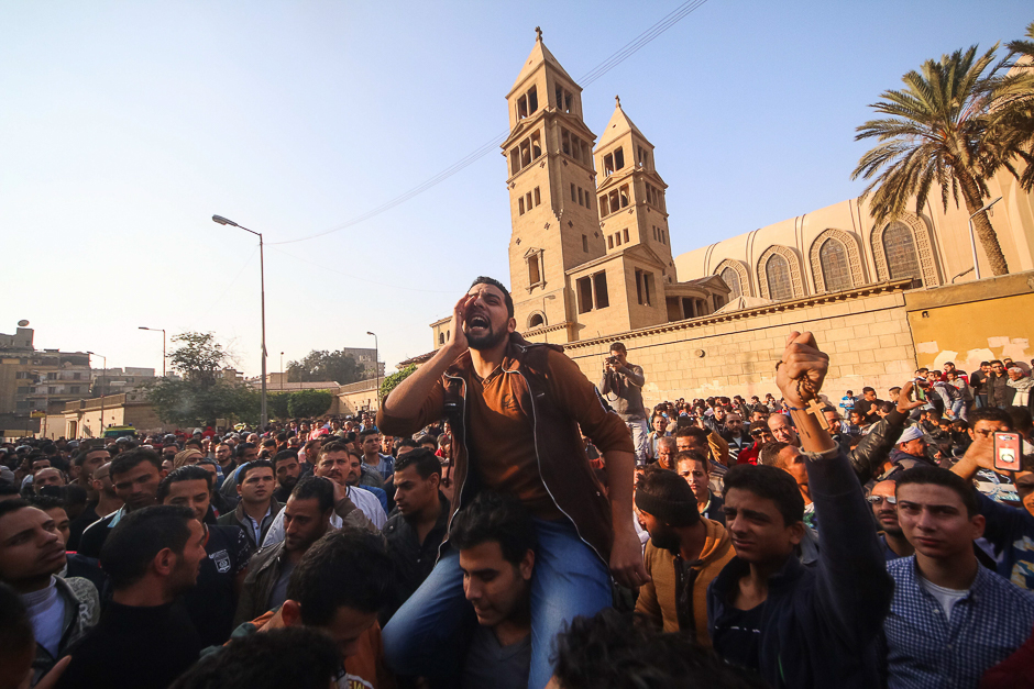 Egyptians shout slogans as they gather outside the Saint Peter and Saint Paul Coptic Orthodox Church in Cairo's Abbasiya neighbourhood after it was targeted by a bomb explosion. PHOTO: AFP