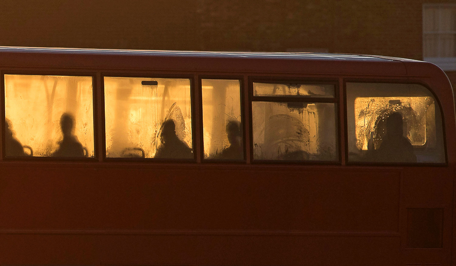 The silhouetted shapes of passengers are seen in the windows on the upper deck of a London bus on Blackheath at sunrise in south east London. PHOTO: AFP