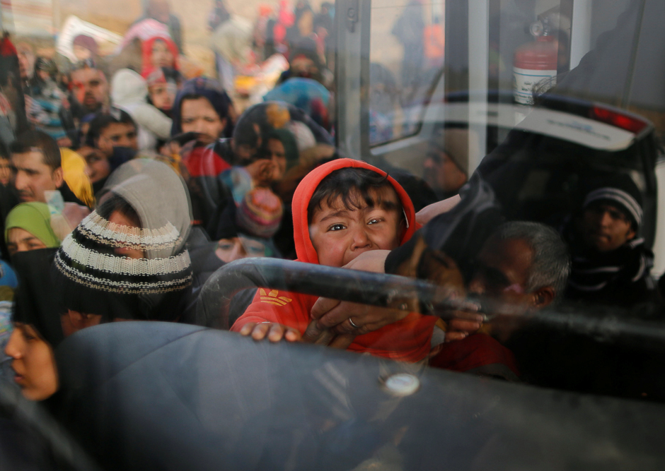 Iraqi people flee the Islamic State stronghold in the town of Bartella, east of Mosul. PHOTO: REUTERS