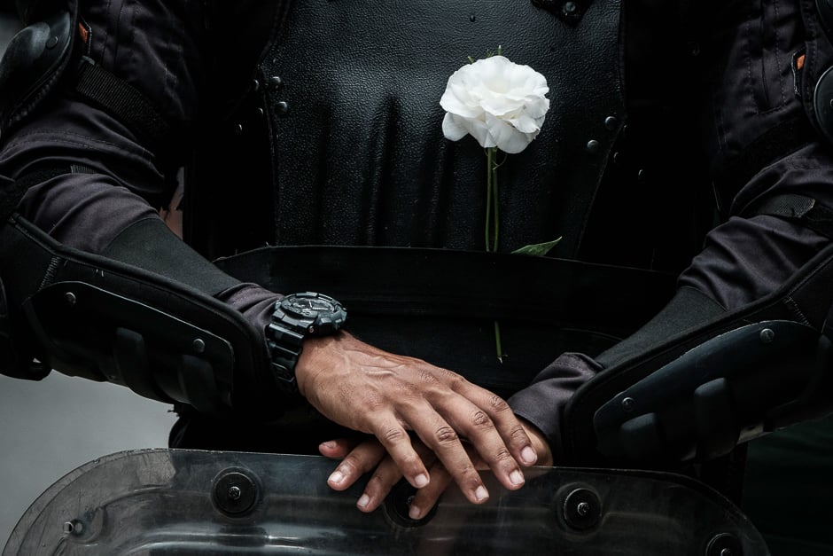 A riot police officer bearing a white flower on his bulletproof vest takes part in a public servants' protest against austerity measures in front of the Rio de Janeiro state Assembly (ALERJ) in Rio de Janeiro, Brazil. PHOTO: AFP